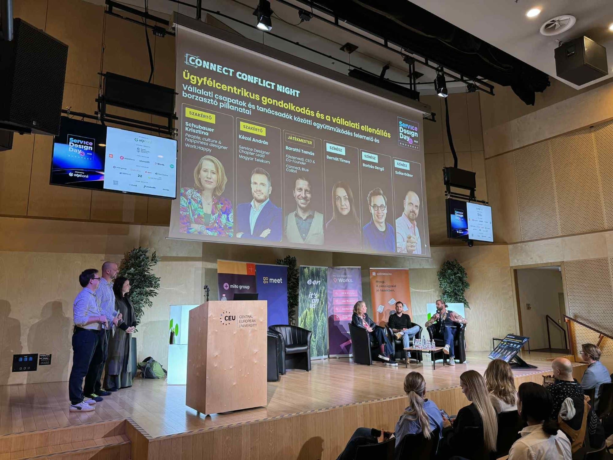 Connect Conflict Night egy szakmai konferencia színpadán: szakértők a fotelekben, színészek a színpad szélén