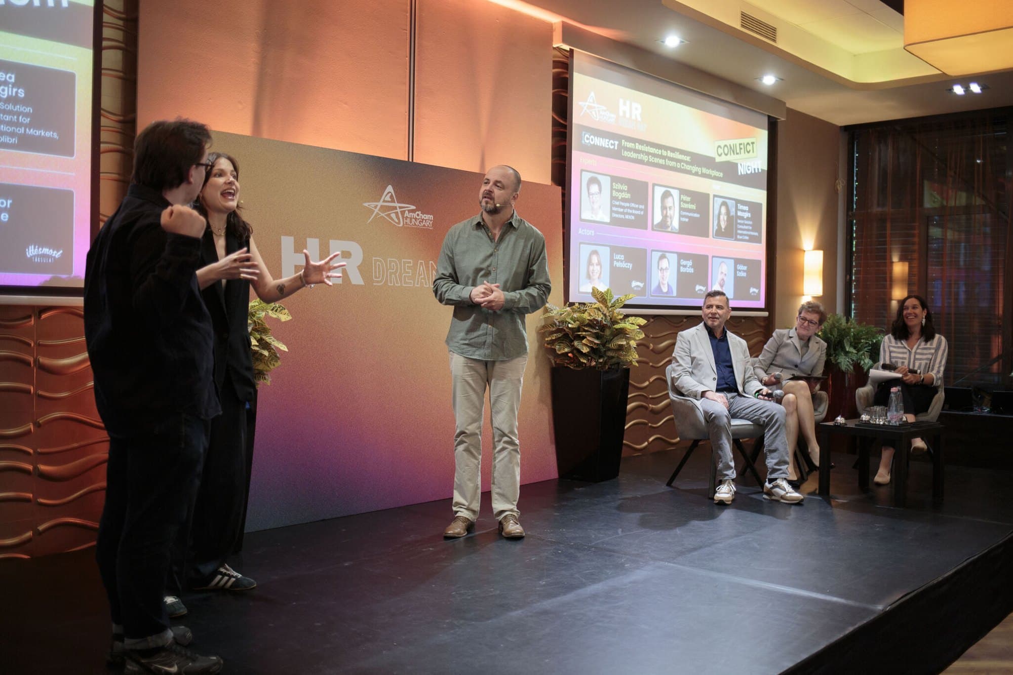 Improvizációs jelenet egy céges Conflict Night előadáson, a szakértők a színpad szélén ülnek